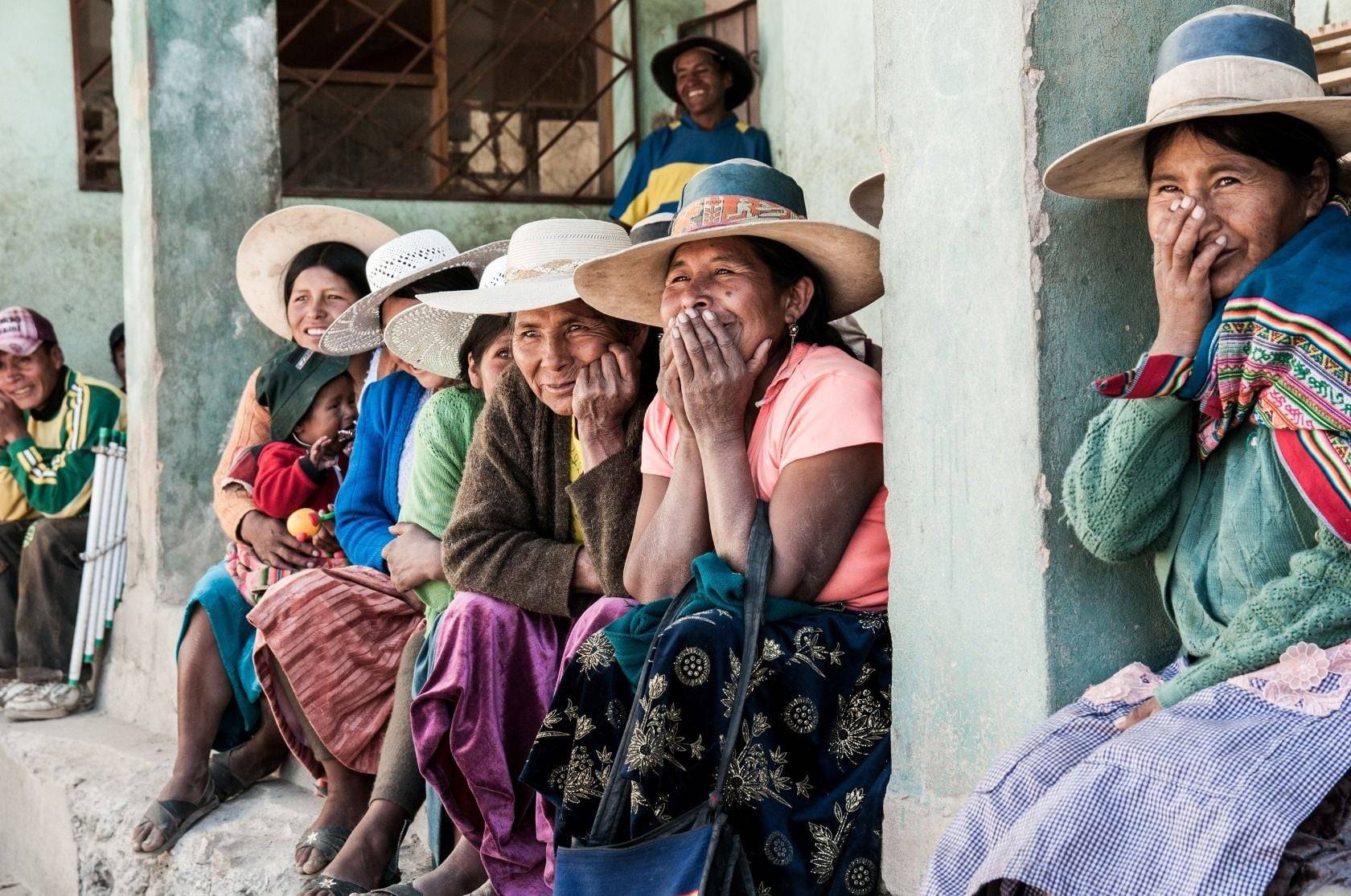 Panoramic view of Bolivia’s Uyuni Salt Flats under a blue sky with distant mountains and 4x4 vehicles crossing the white salt crust