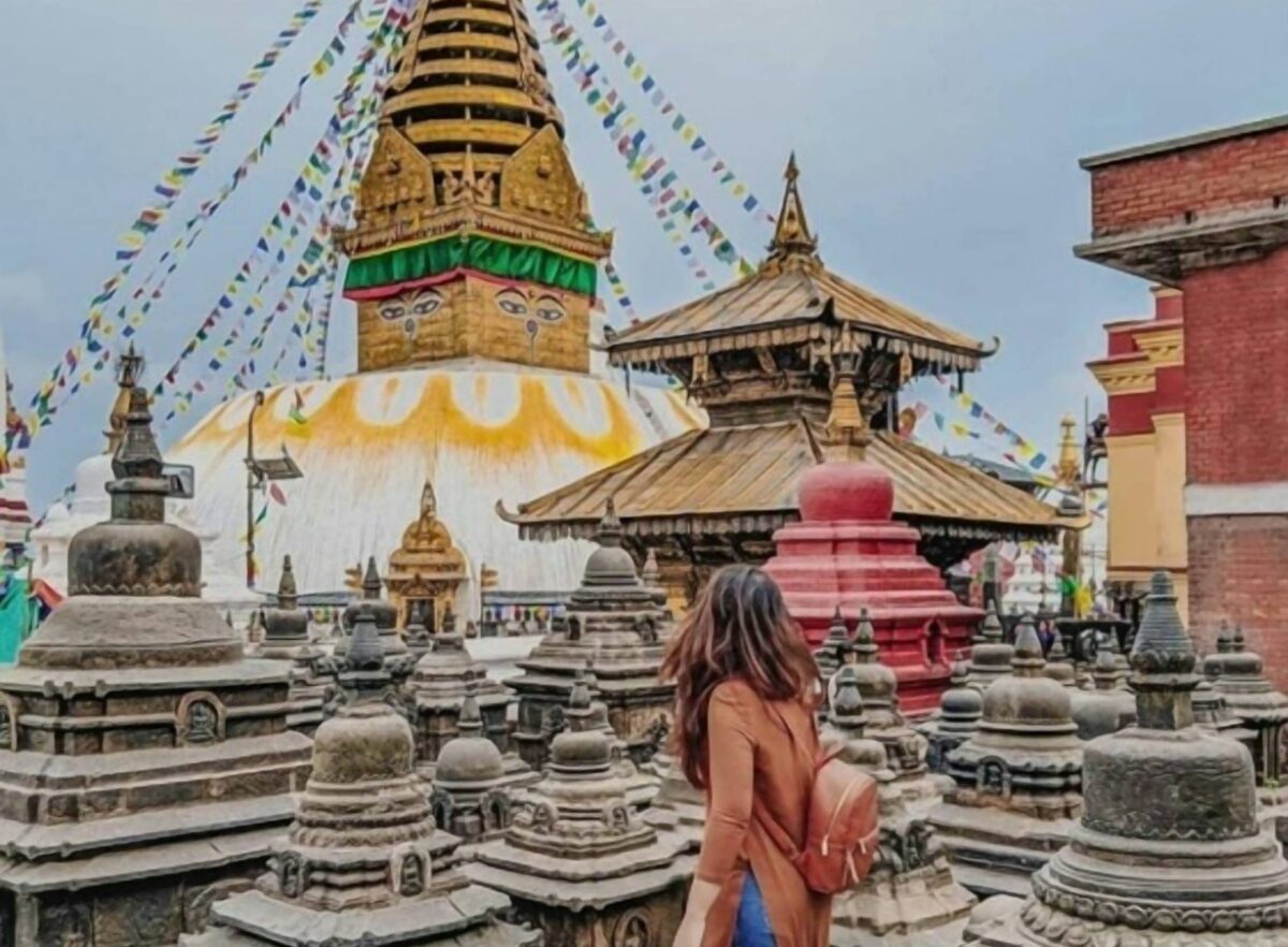 Panoramic view of Boudhanath Stupa in Kathmandu with prayer flags and pilgrims circling the white dome