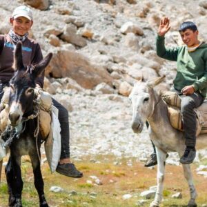Panoramic view of Cappadocia’s fairy chimneys and rock formations at sunrise with a traditional village in the foreground in Turkey