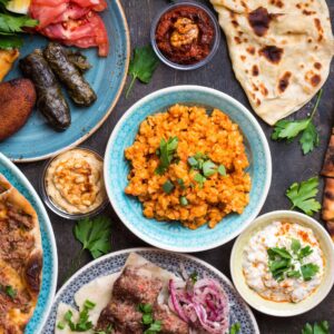 Panoramic view of Cappadocia’s fairy chimneys at sunset with stone houses and valleys under a colorful sky in Turkey