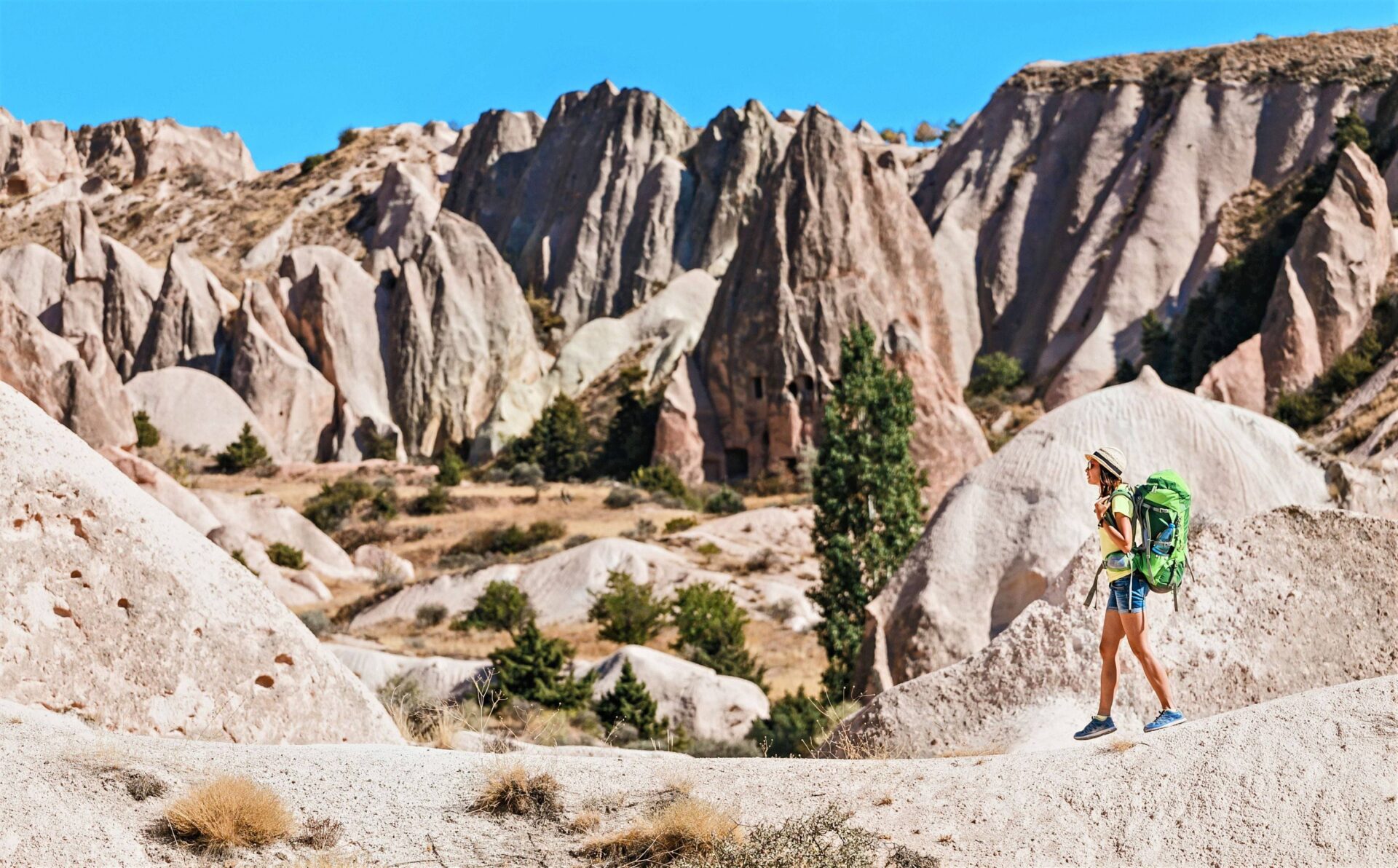 Panoramic view of Cappadocia’s rocky valleys at sunrise with volcanic formations and scattered cave dwellings