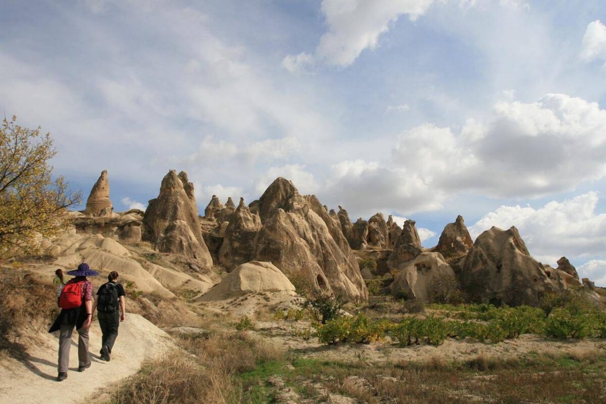 Panoramic view of Cappadocia’s valleys with fairy chimneys and rock-cut houses under a blue sky