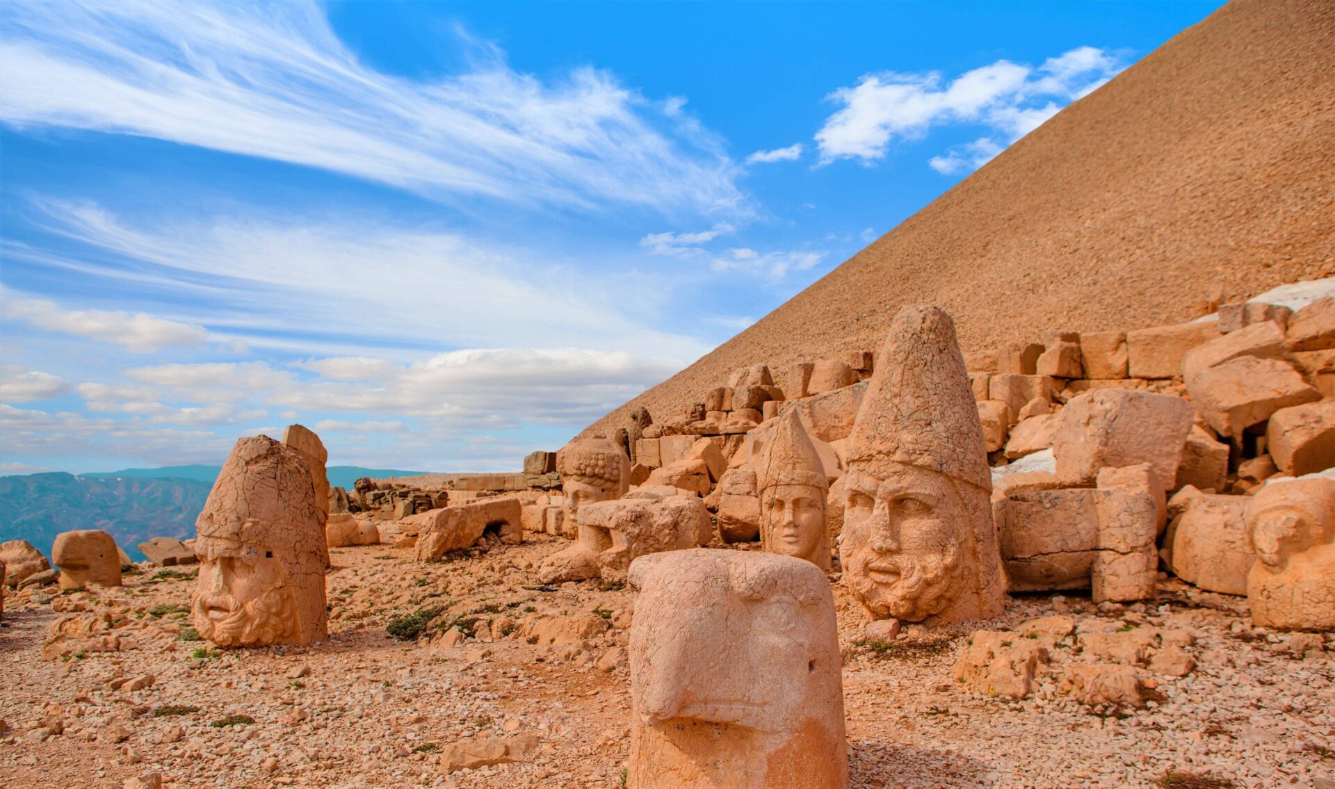 Panoramic view of Eastern Turkey’s rugged mountains at sunset, with ancient ruins silhouetted against an orange sky