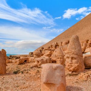 Panoramic view of Eastern Turkey’s rugged mountains at sunset, with ancient ruins silhouetted against an orange sky