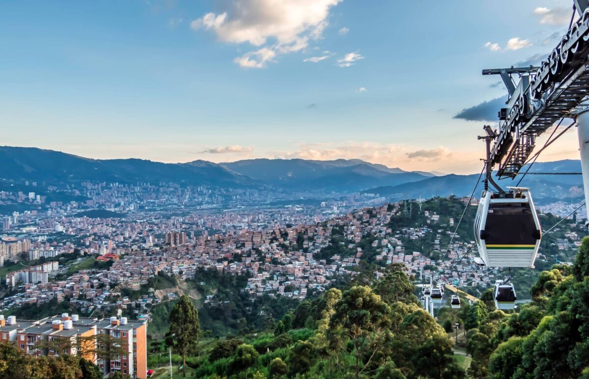 Panoramic view of Medellín with cable cars running over colorful hillside neighborhoods