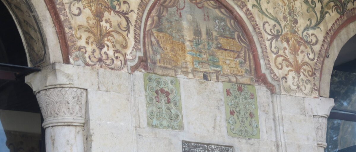 Passenger walking through the departure hall of Tirana International Airport with large windows and aircraft visible outside