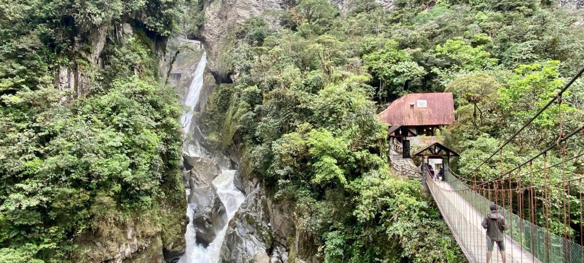 Powerful Pailón del Diablo waterfall crashing into a gorge surrounded by green vegetation near Baños