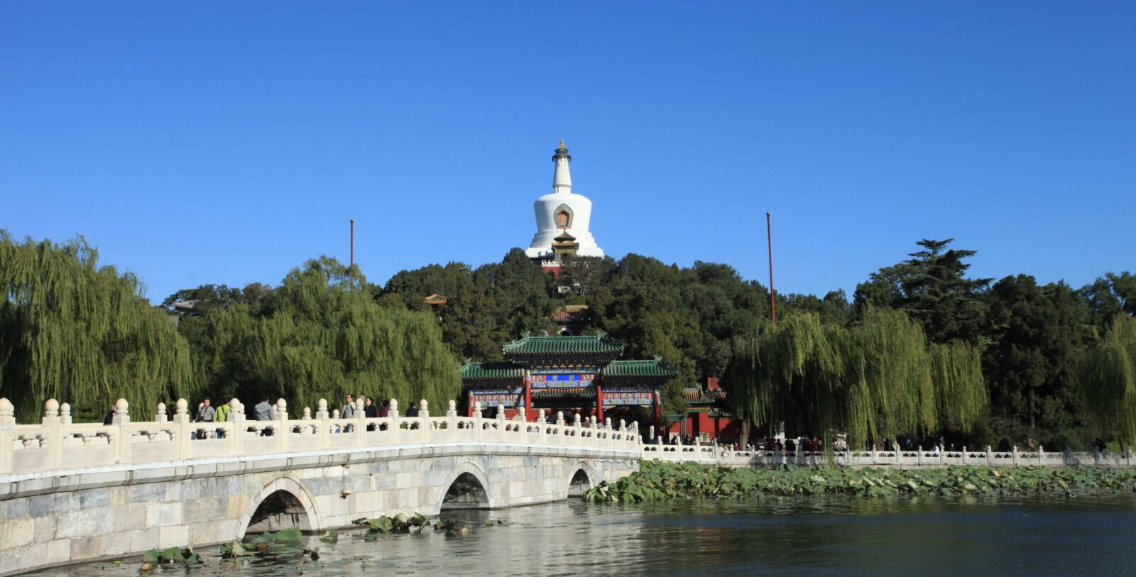 International travelers arriving at Beijing Capital Airport terminal with Chinese signage