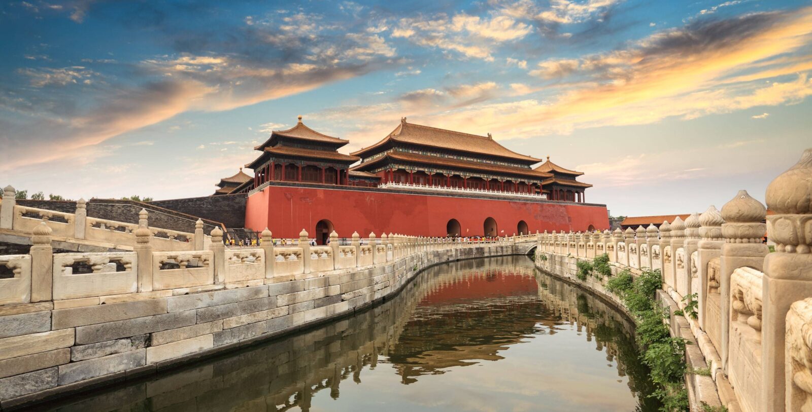Tourists walking across Tiananmen Square with the Gate of Heavenly Peace in the background in Beijing