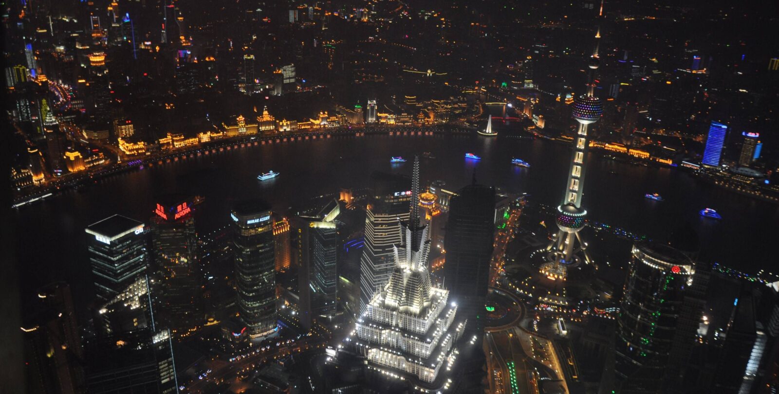 Night view of Shanghai skyline with the Oriental Pearl Tower and modern skyscrapers seen from the Bund waterfront promenade