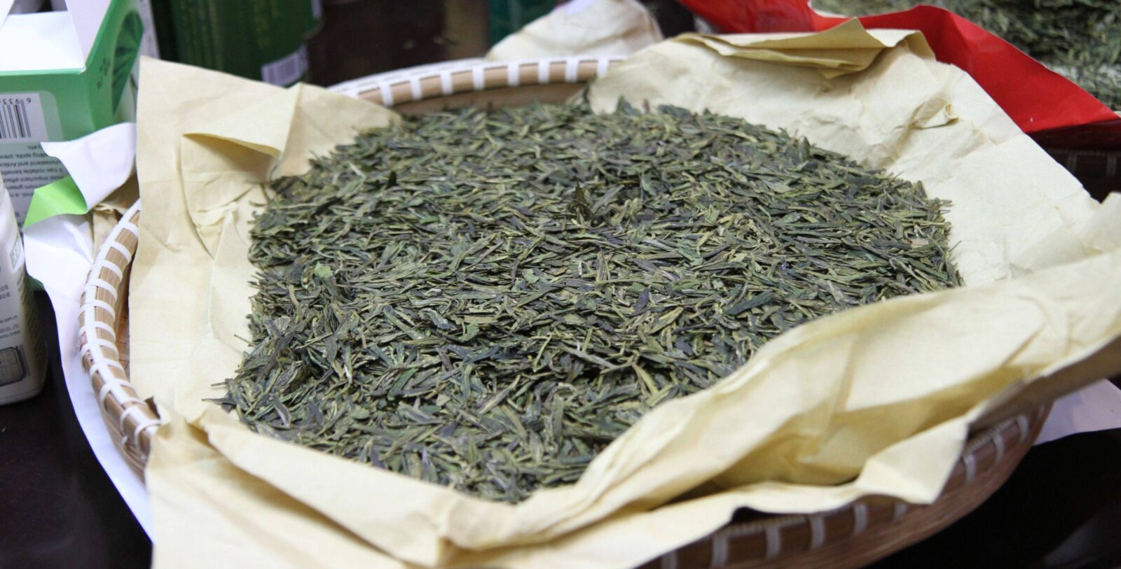Green terraced tea fields around Longjing village near Hangzhou with misty hills in the background