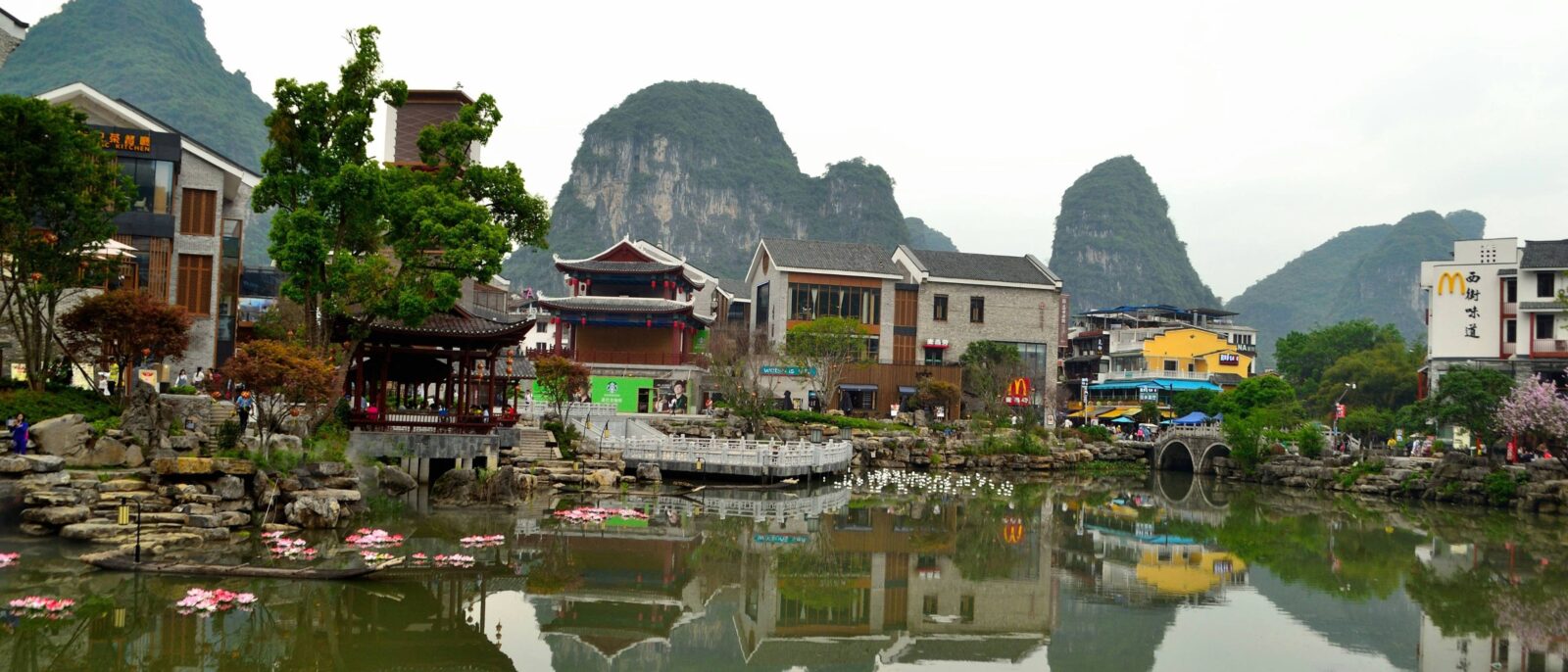 Family standing on the deck of a boat during a Li River cruise, surrounded by dramatic karst mountains on the way to Yangshuo