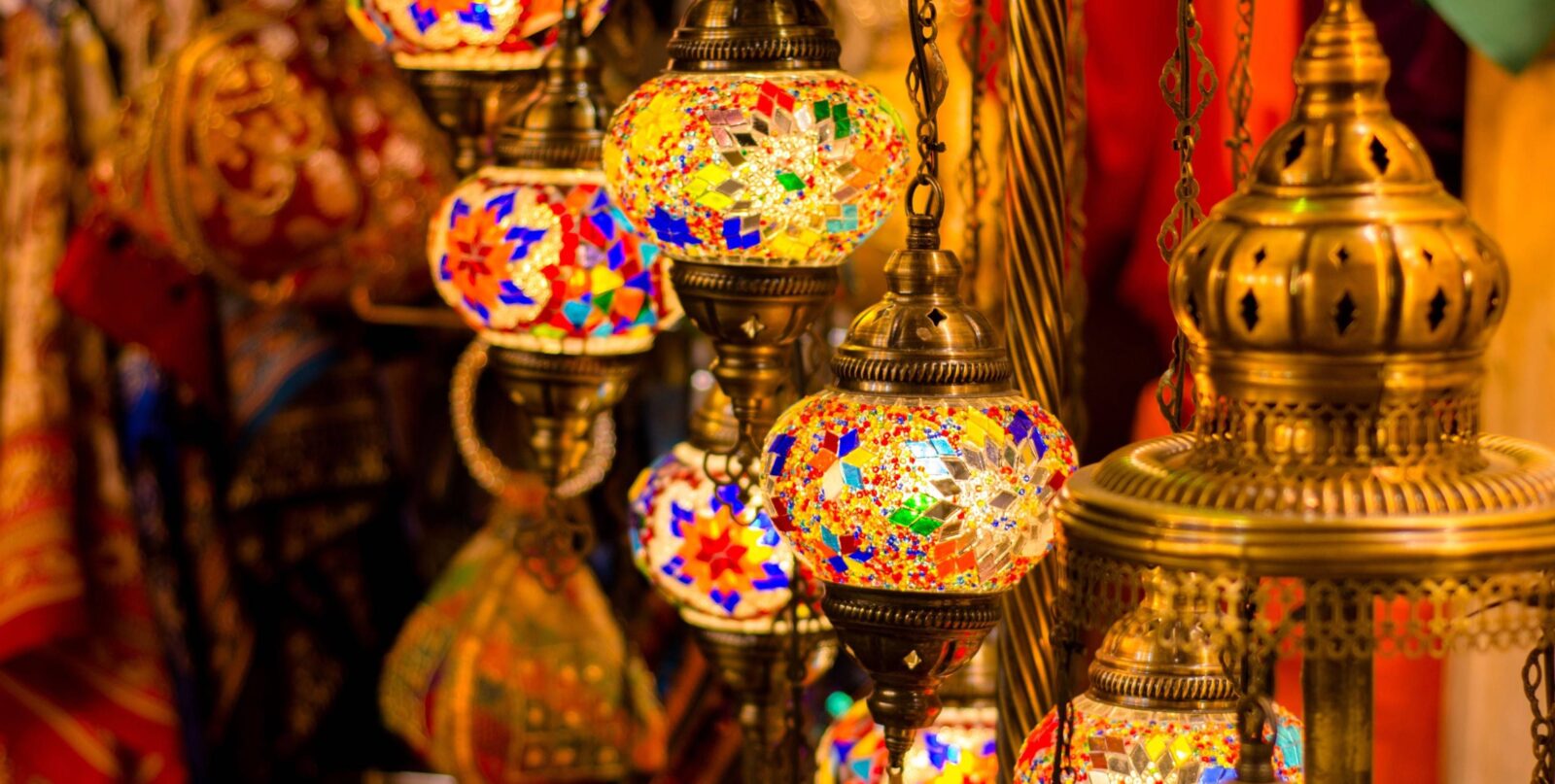 Night view of Muscat, Oman with illuminated buildings and mountains in the background