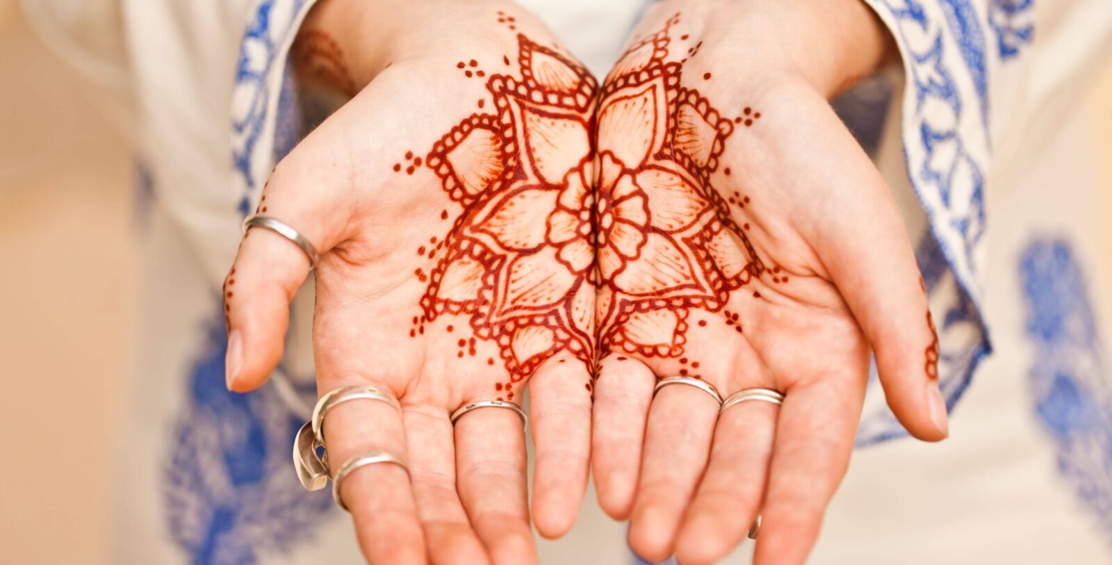Exterior view of Sultan Qaboos Grand Mosque in Muscat, Oman with domes and minaret under a clear blue sky