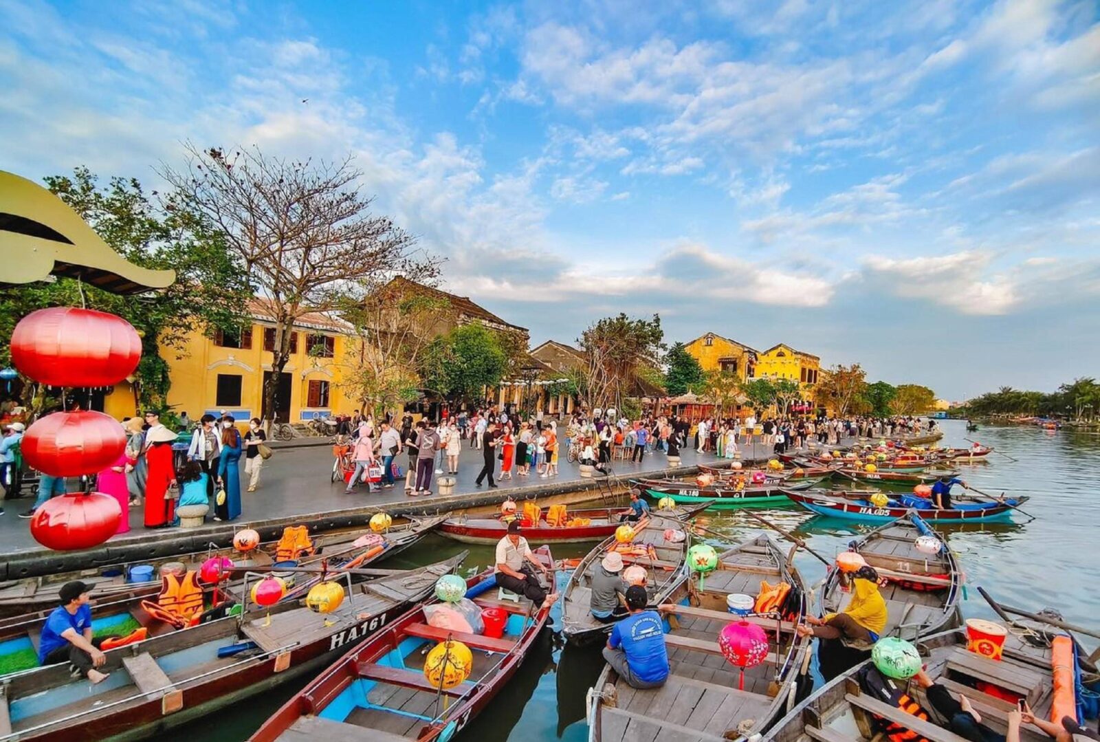 Lantern-lit riverside scene in Hoi An ancient town at dusk with reflections on the water