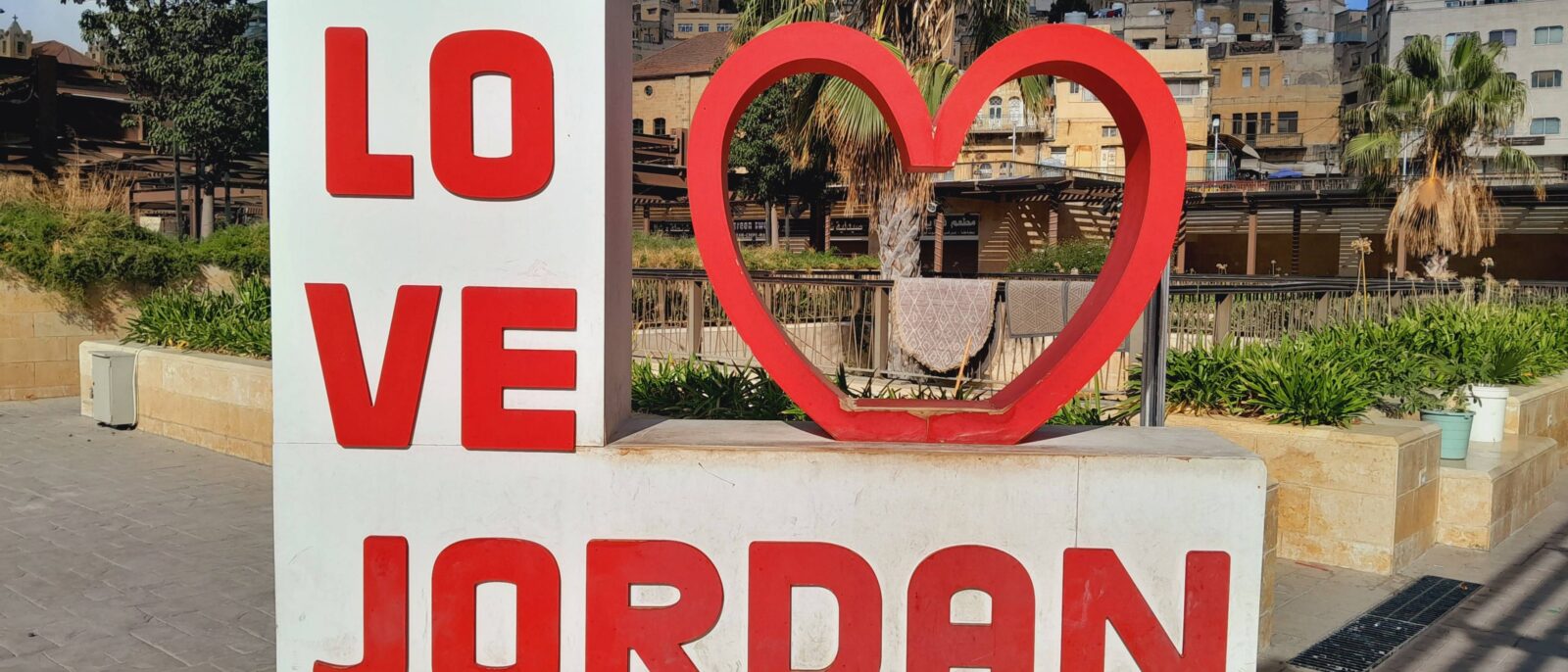 View over the city of Amman at sunset with light-colored houses spread across the hills