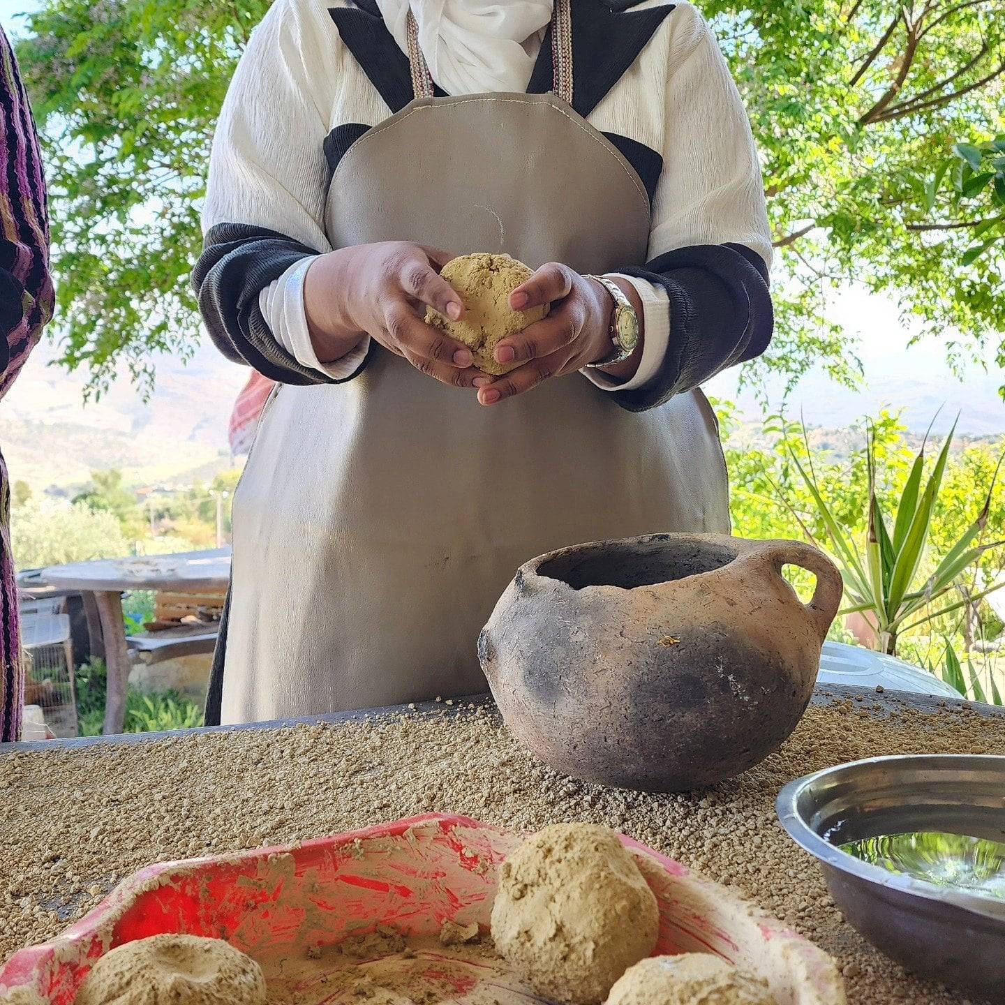 Family walking along a colonnaded Roman street in Jerash, Jordan, under a bright blue sky