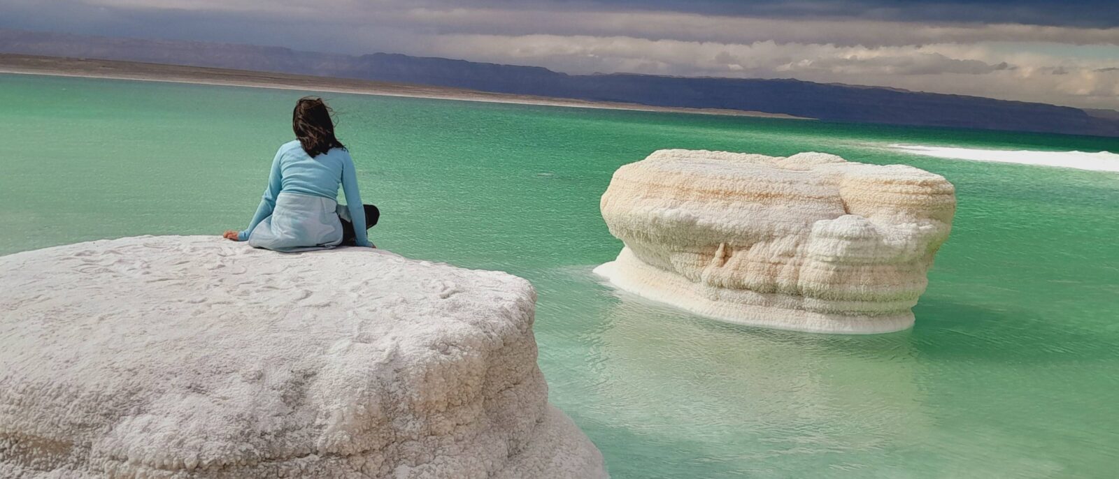 Family floating on their backs in the Dead Sea covered with therapeutic mud