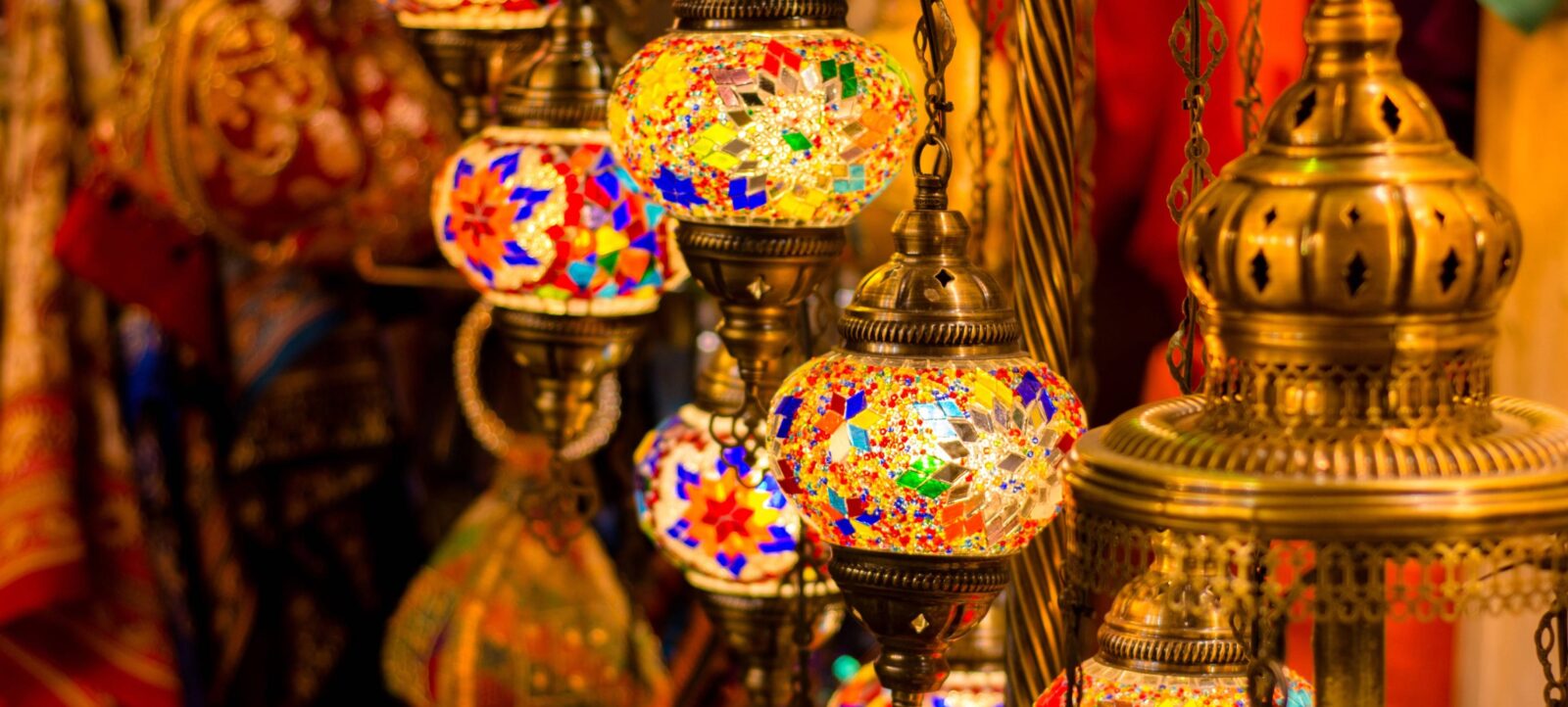 Evening view of Muscat with city lights, mountains in the background and arriving travellers at the airport