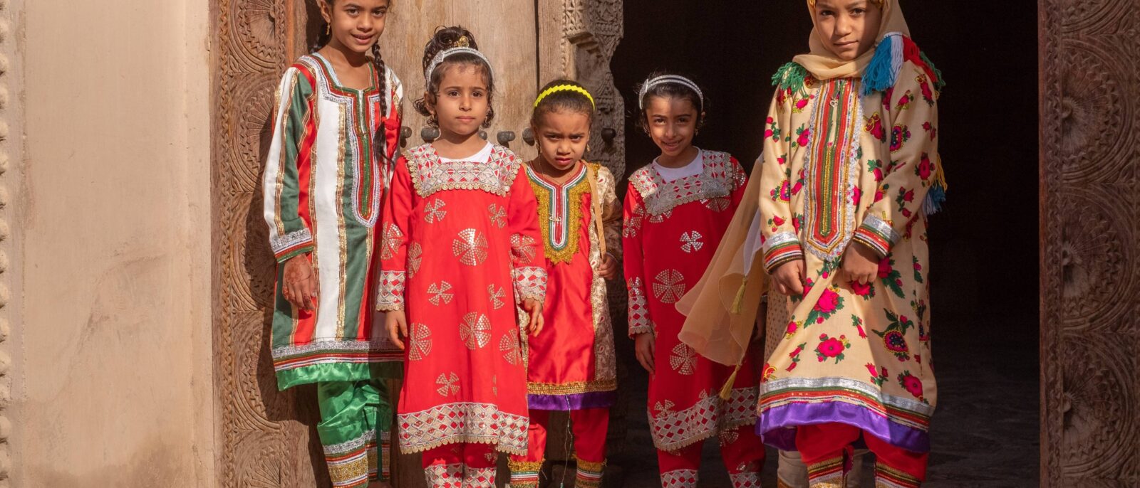 Night view of Muscat with illuminated buildings and mountains in the background