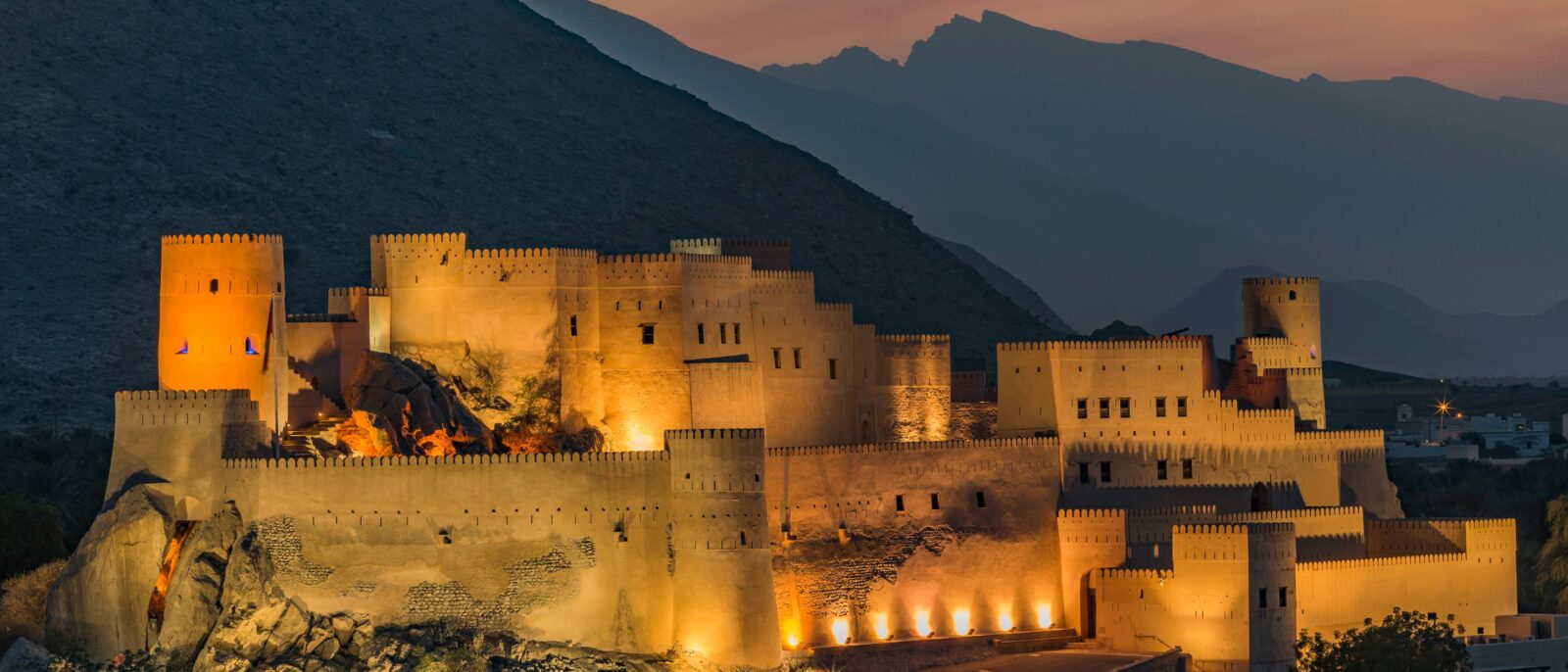 Sultan Qaboos Grand Mosque in Muscat with white domes and minarets under a blue sky