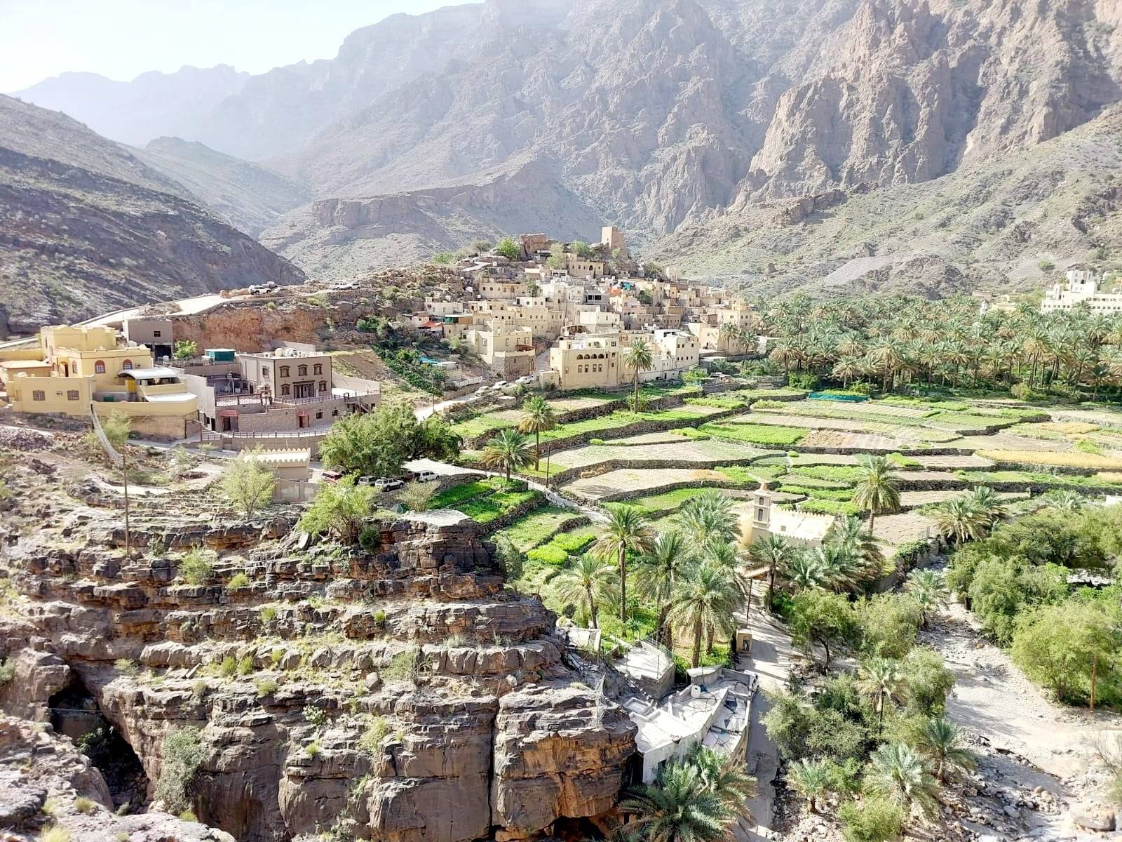 4x4 vehicle driving on a gravel road through Oman’s rugged mountain valley
