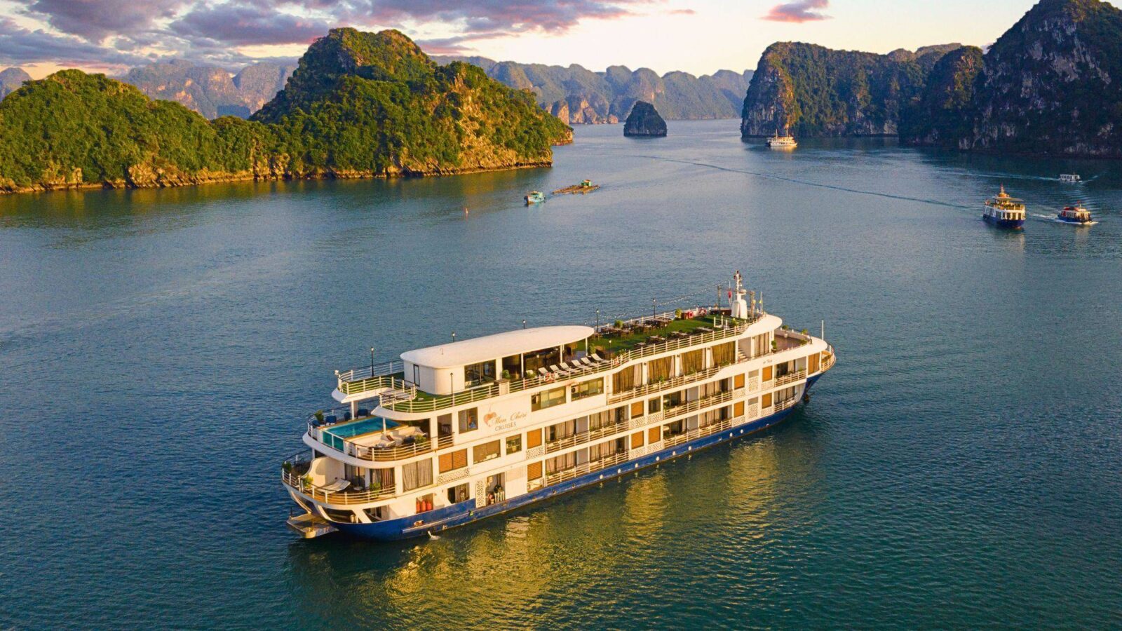 Traditional wooden junk boat sailing among towering limestone islands in Halong Bay, Vietnam