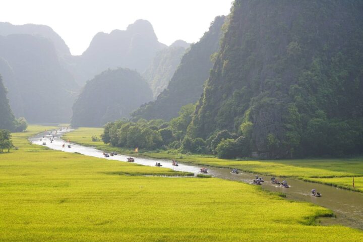 Romantic couple cruising among limestone karsts at sunset in Ha Long Bay, Vietnam