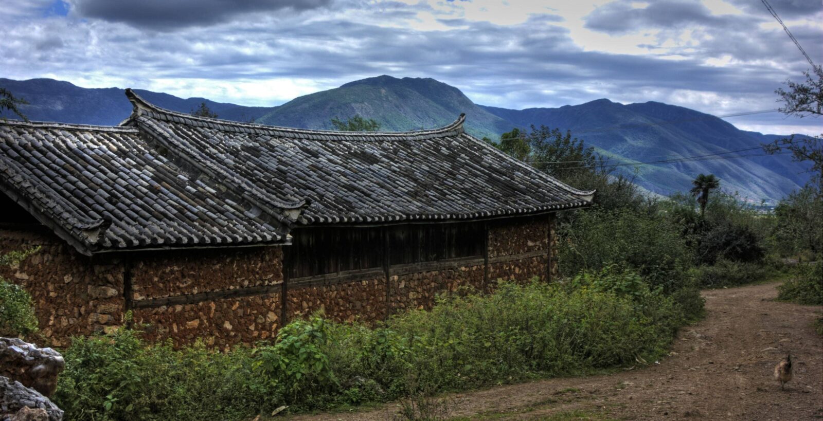 Hikers approaching the remote Naxi village of Wenhai beside a mountain lake in Yunnan