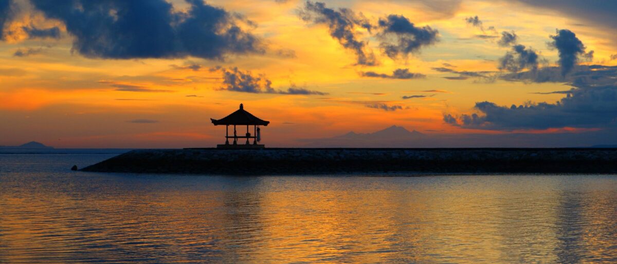 Quiet morning on Sanur beach in Bali with calm sea, fishing boats and palms