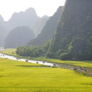 Romantic couple cruising among limestone karsts at sunset in Ha Long Bay, Vietnam
