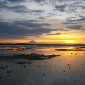 Romantic couple relaxing by a private pool villa surrounded by tropical greenery at a boutique eco-resort in Bali at sunset