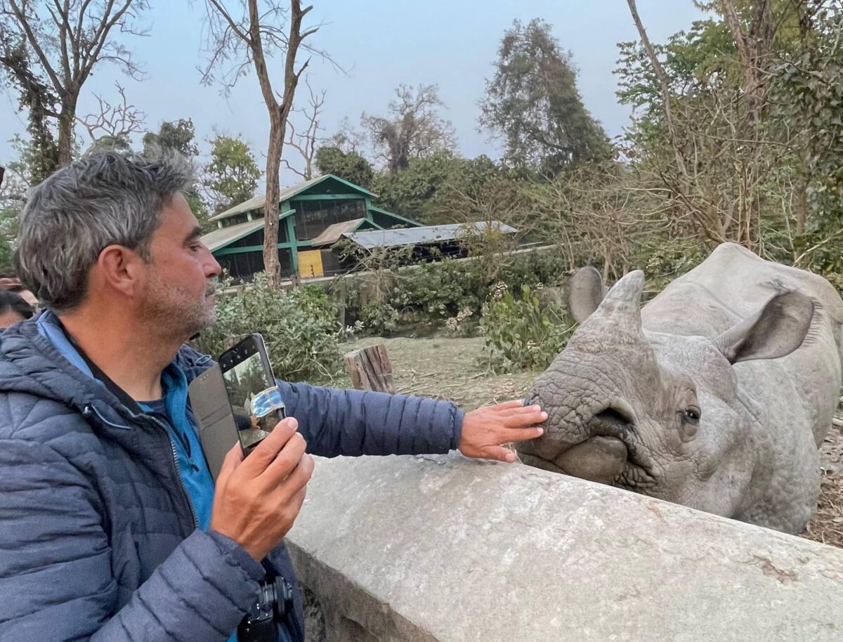 Rural road lined with green fields and trees leading towards the forests of Bardia National Park in Nepal