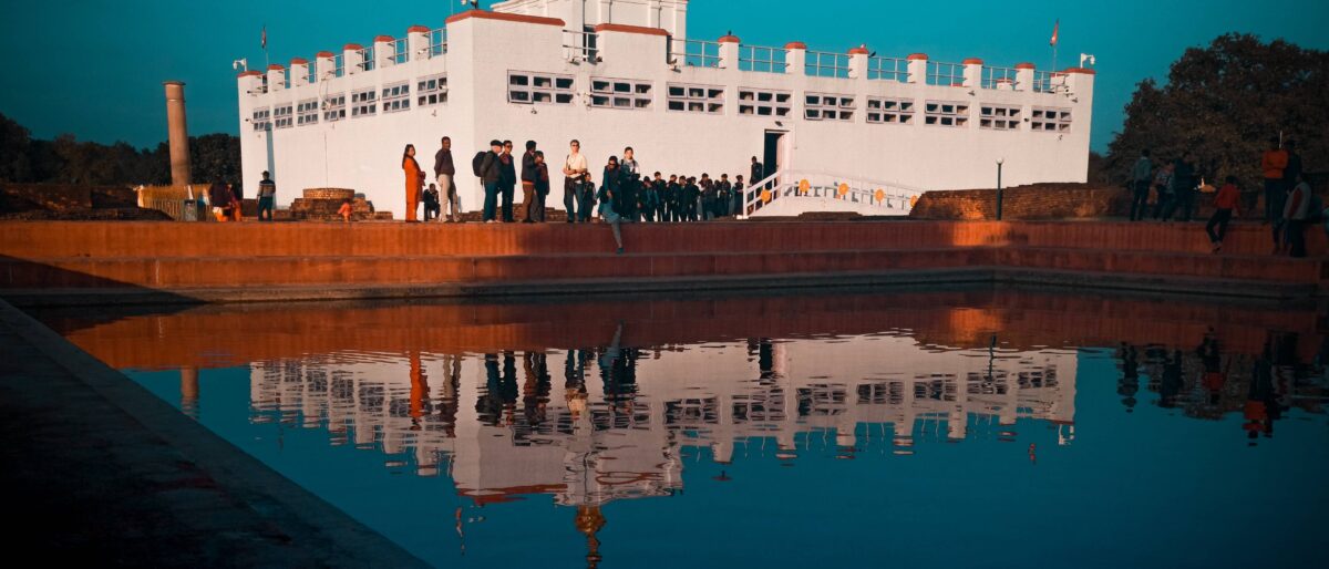 Sacred garden area in Lumbini with brick ruins, prayer flags and a serene temple in the background