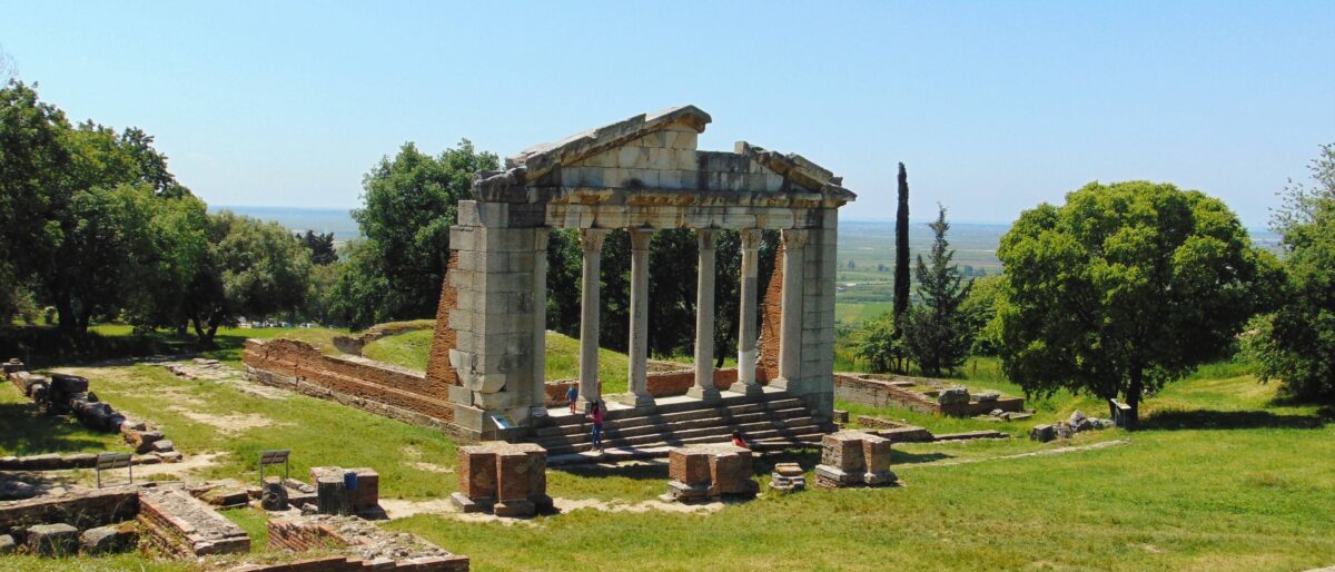 Skanderbeg Square in Tirana with National History Museum, clock tower and people walking