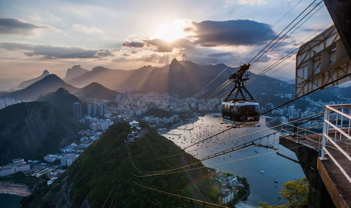 Small pier on Ilha Grande with boats ready to depart and forested hills in the background at sunrise