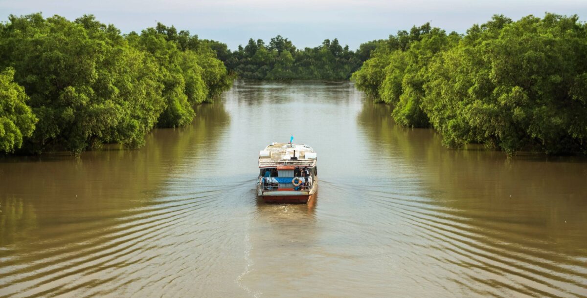 Small rustic wooden Amazon riverboat Iara moored on the dark Rio Negro surrounded by lush green rainforest