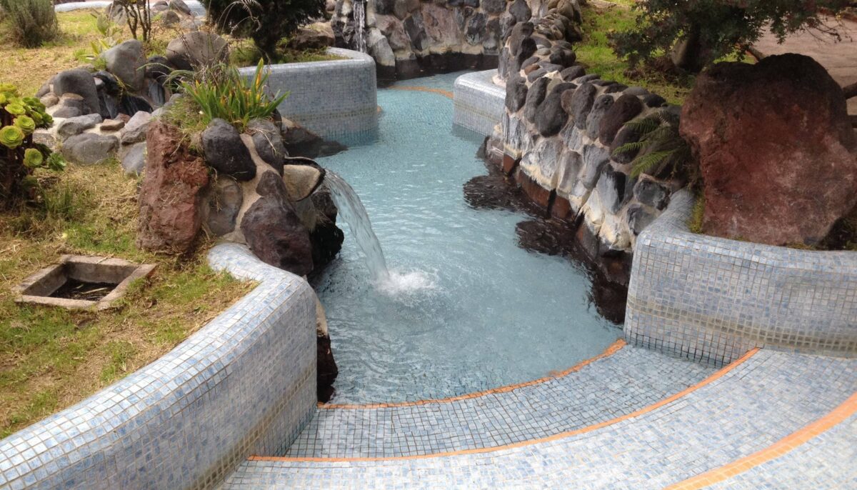 Steam rising from thermal pools at Papallacta with cloud-covered Andean mountains in the background