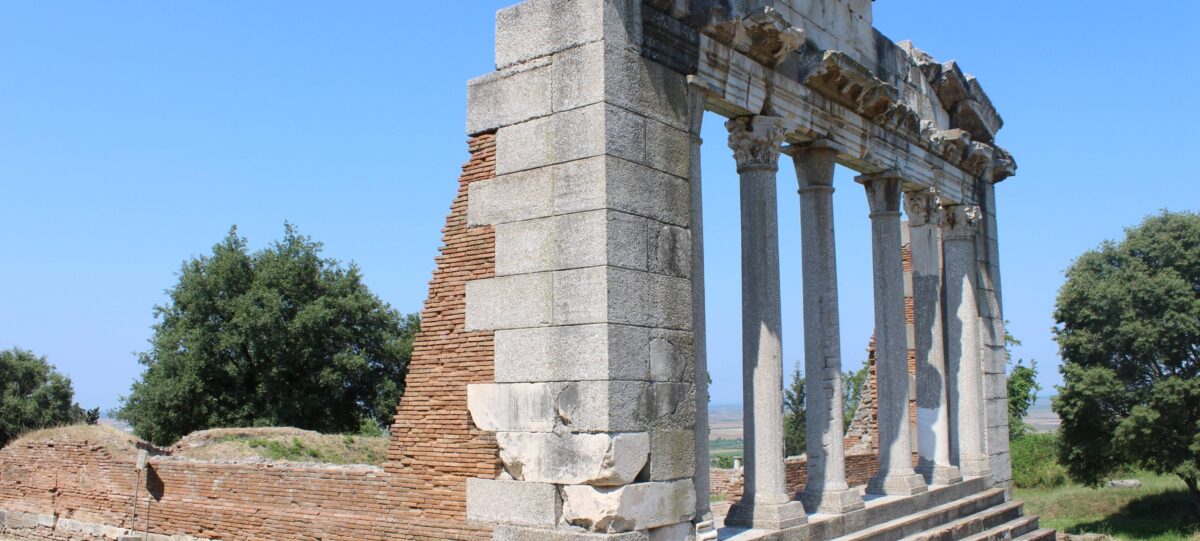 Stone buildings of Ardenica Monastery in Albania surrounded by greenery under a blue sky