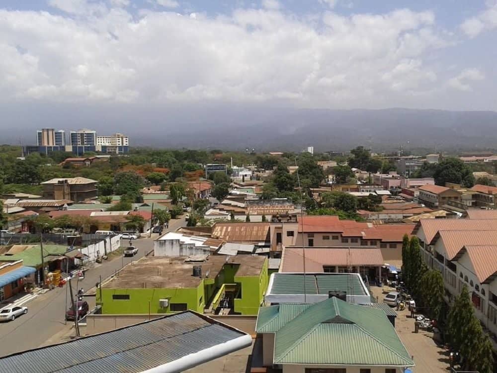 Street in Moshi town with colonial-era buildings, shops and people walking