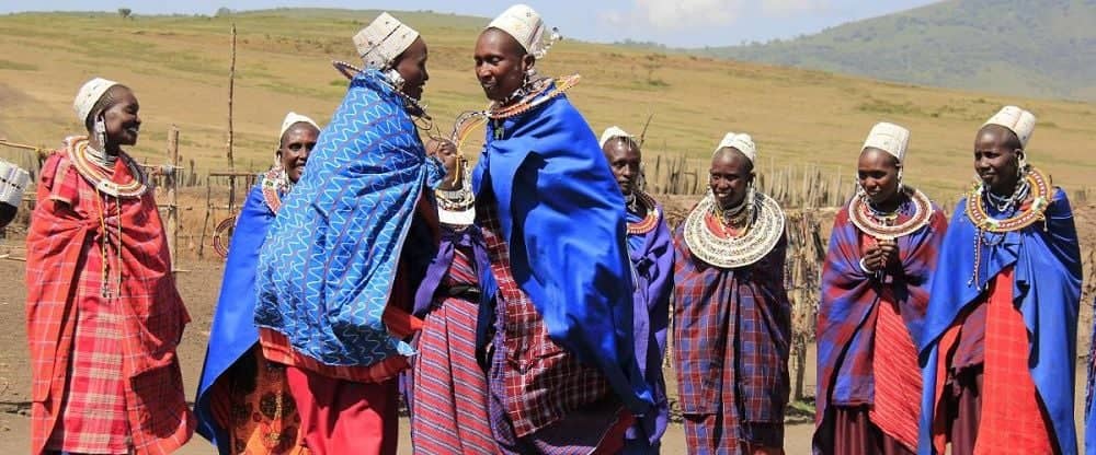 Street scene in Mto wa Mbu with local market stalls and people walking near banana plantations