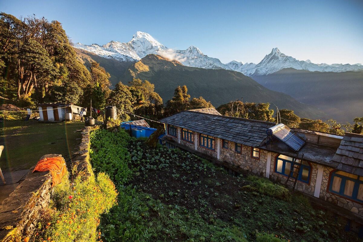 Sunrise view from Poon Hill with the silhouettes of trekkers and the snow-covered Dhaulagiri and Annapurna ranges glowing in golden light