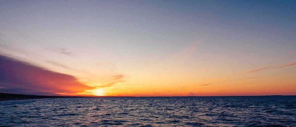 Sunset view over Labuan Bajo harbour with boats anchored and islands on the horizon