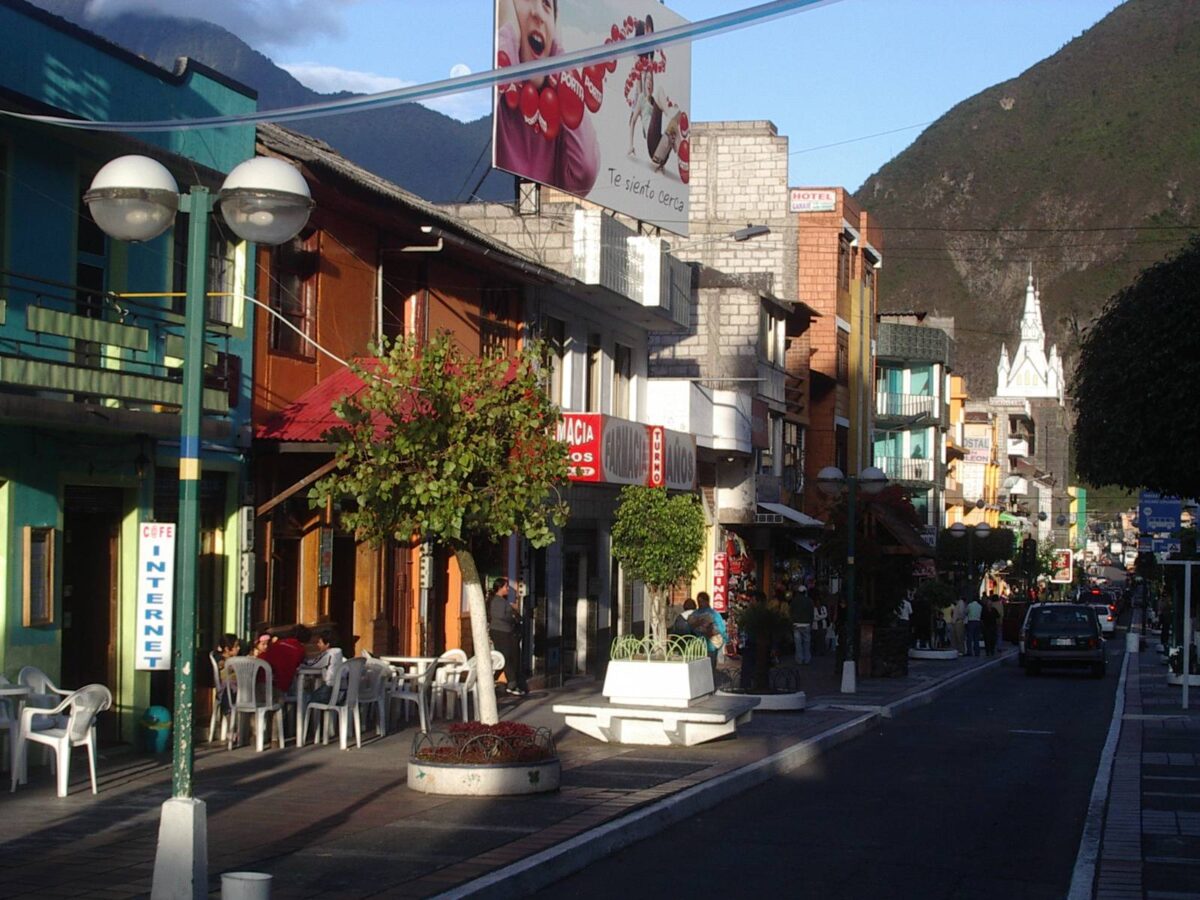 Suspension basket crossing a deep canyon towards a powerful waterfall near Baños, Ecuador