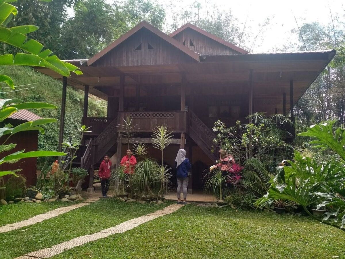 Toraja villagers walking between traditional tongkonan houses with curved roofs in a mountain village