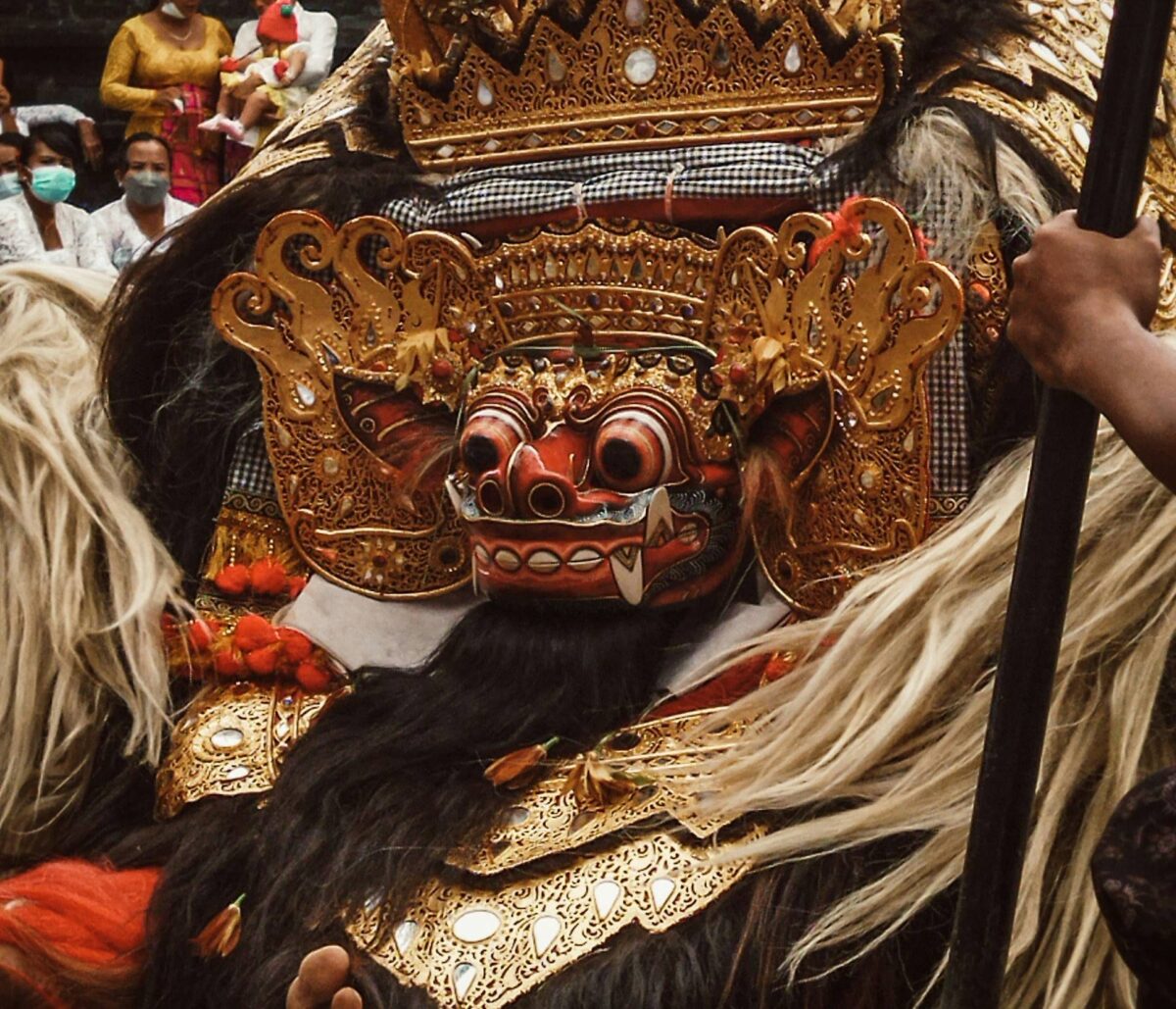 Traditional Balinese Barong dancers performing in colorful costumes in front of an audience