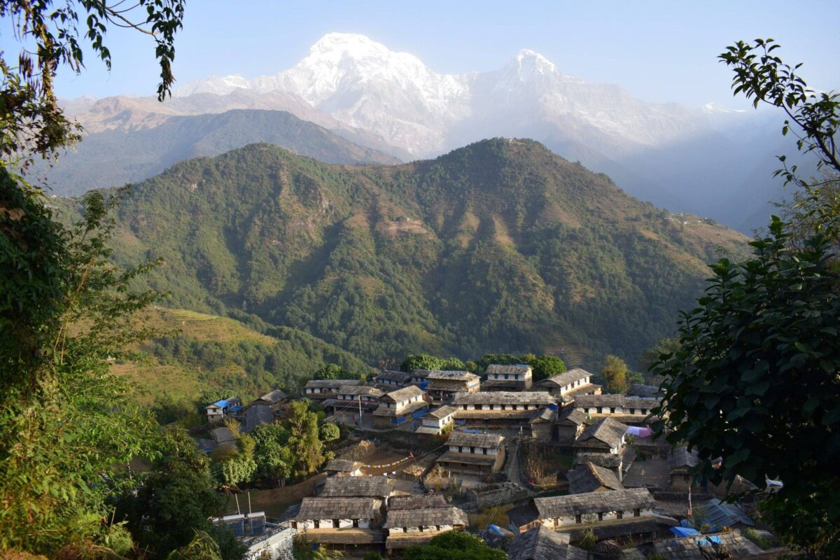 Traditional Gurung village of Ghandruk with stone houses, terraced fields and Annapurna peaks in the background