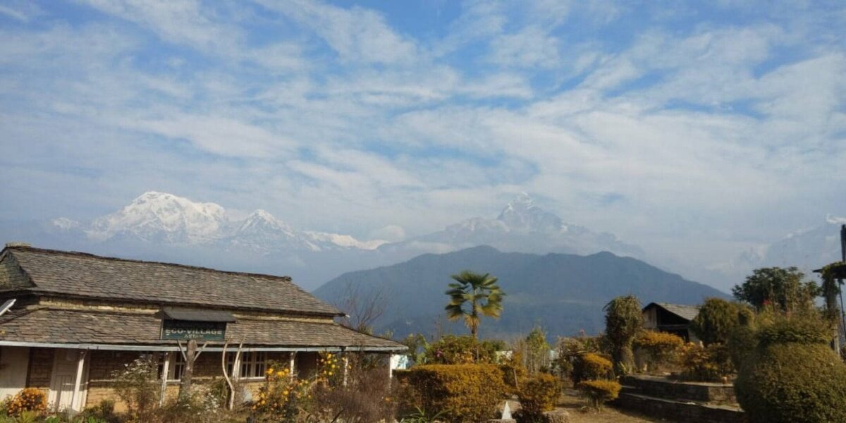 Traditional houses of Astam village on a green ridge with a panoramic view of the Annapurna mountain range
