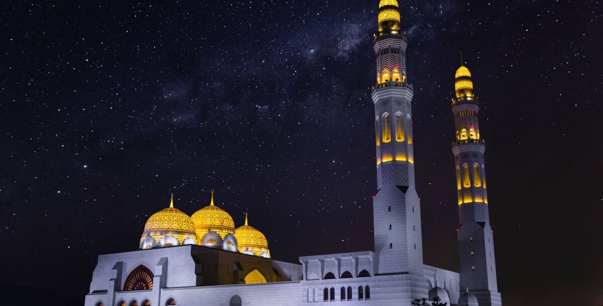 Traditional livestock market in Nizwa, Oman with people in white dishdashas trading goats and cattle