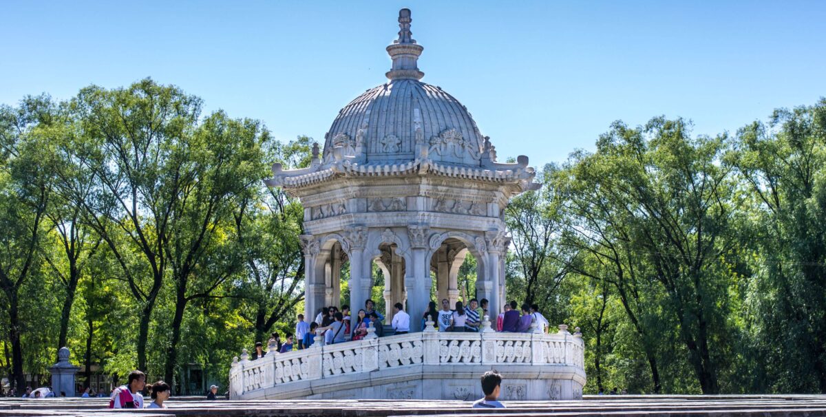 Traditional pavilions and arched bridge of the Summer Palace reflected in Kunming Lake in Beijing